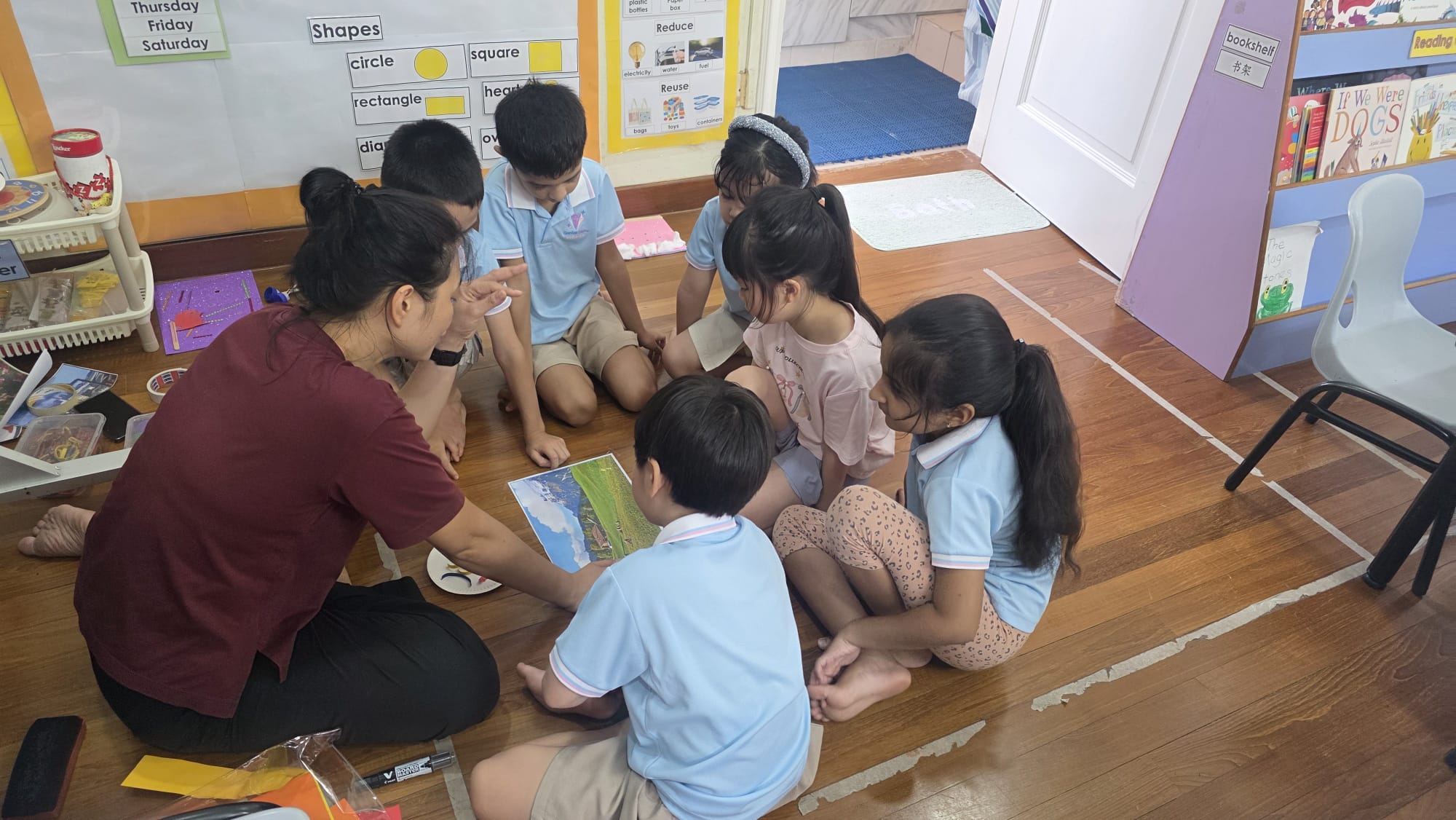 Teacher guiding Kindergarten 2 (K2) children during a classroom lesson at Genius Gems Childcare Centre