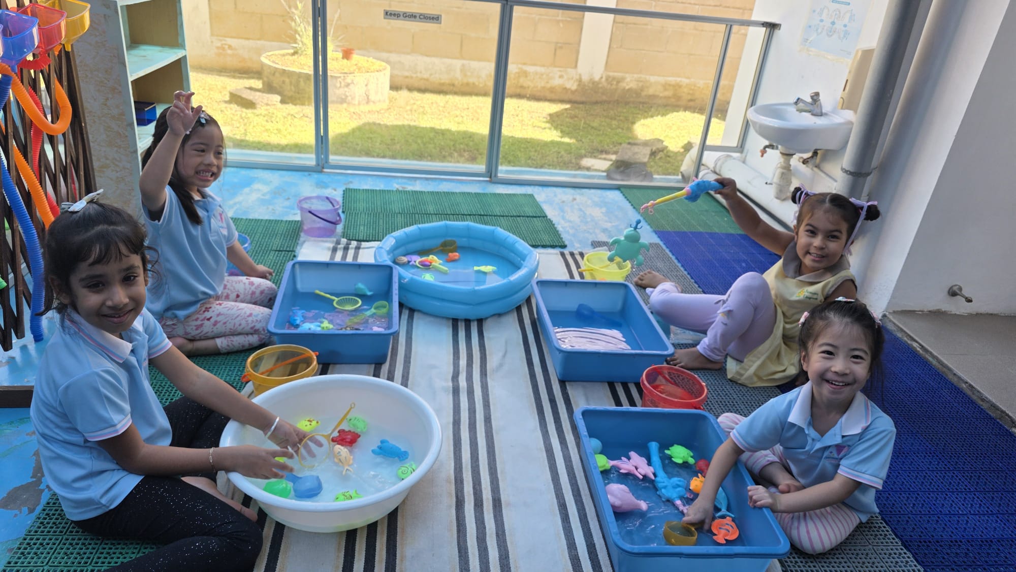 Children sharing a water play table at Genius Gems Childcare Centre